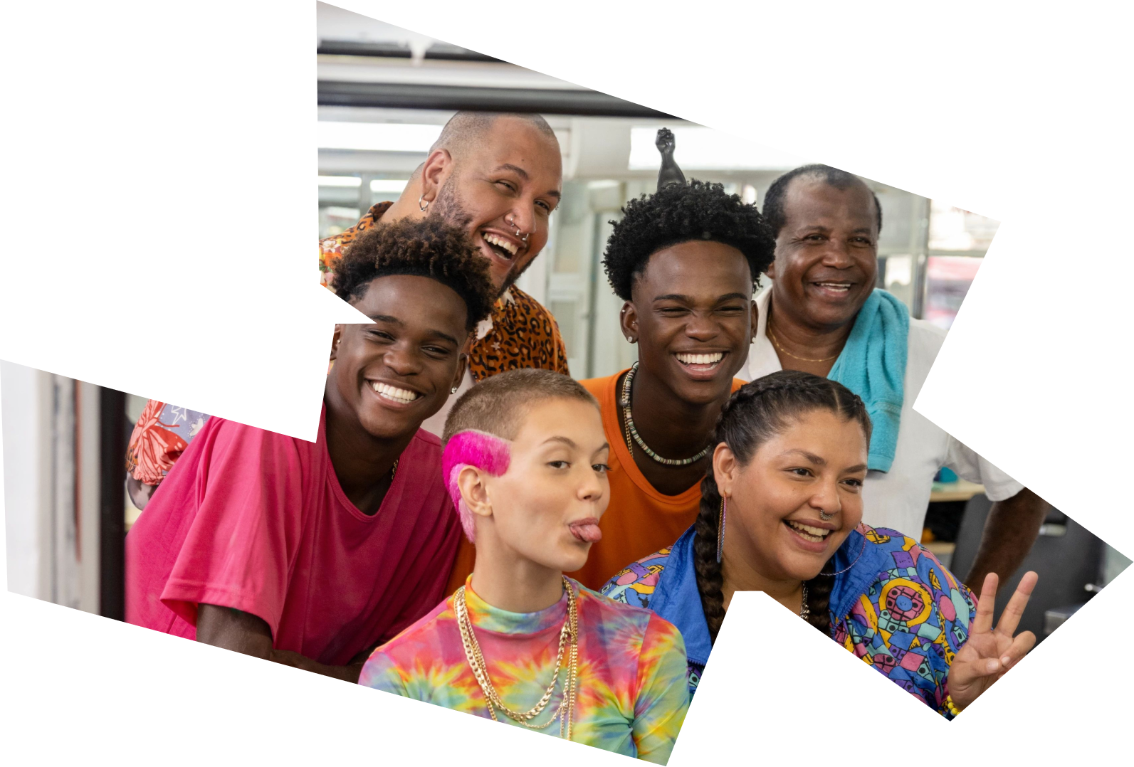 A diverse and multi-generational group of friends smile and laugh as they take a selfie together.