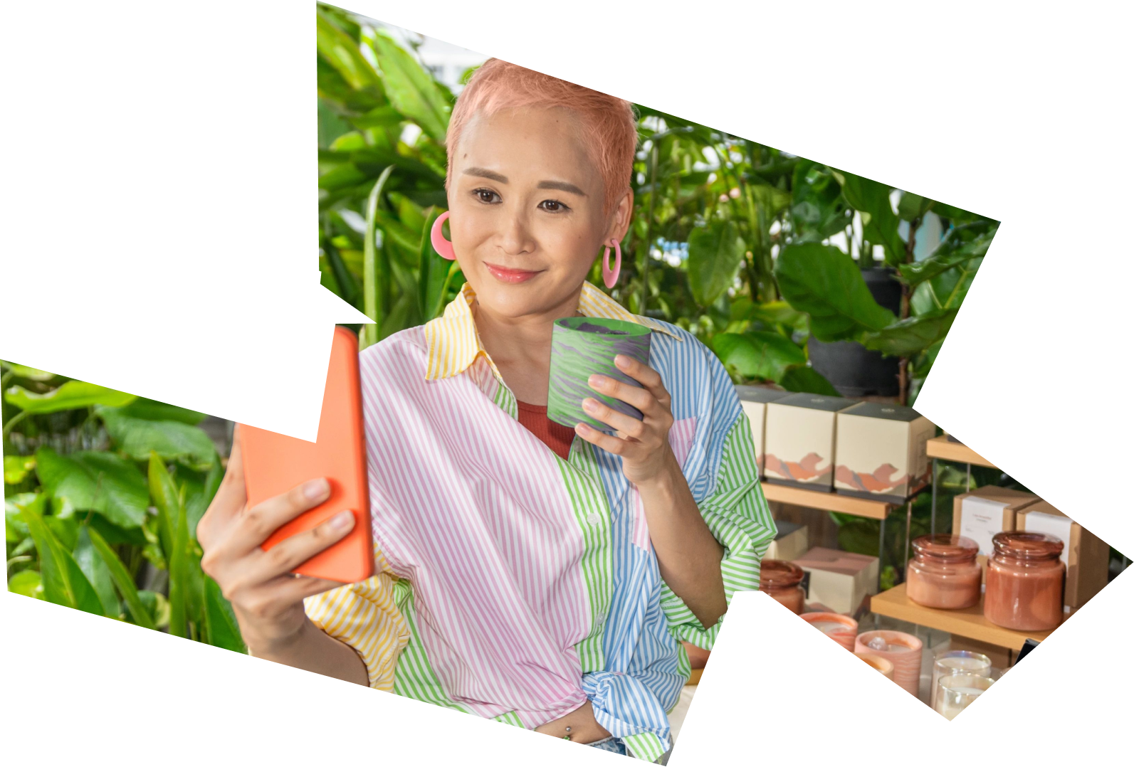 A young Asian woman in a store takes a selfie as she holds a decorated pot.